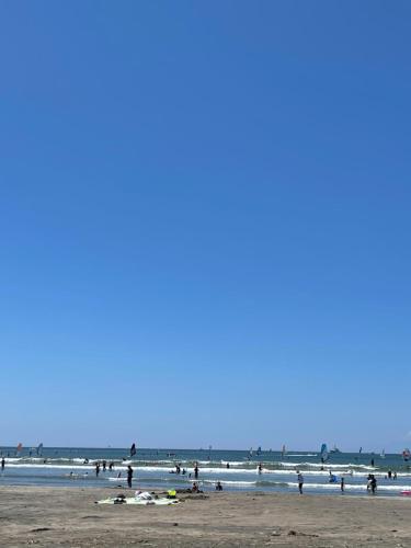 a group of people on a beach with the ocean at Children's cafe B&B Kimie in Kamakura