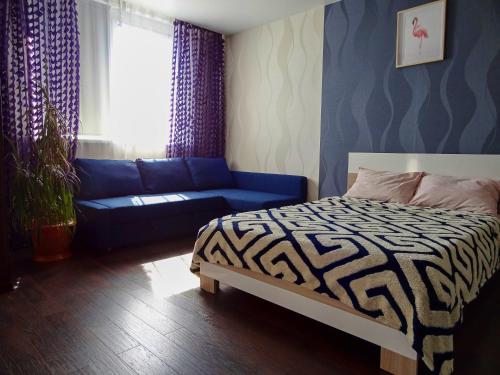 ノヴォシビルスクにあるLoft Studioのベッドルーム(ベッド1台、青いソファ付)