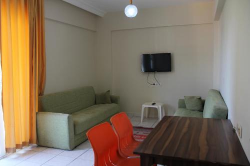 sala de estar con sofá, mesa y sillas en Le Moral Apart Hotel en Alanya