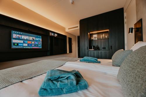 a hotel room with two beds with towels on them at Residence Oude Haven room with terrace in Colijnsplaat