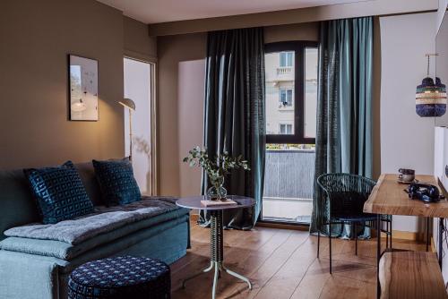 - un salon avec un canapé et une table dans l'établissement Le Garage Biarritz Hôtel, à Biarritz