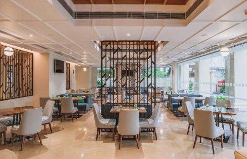 a restaurant with tables and chairs in a building at Holiday Inn Goa Candolim in Candolim