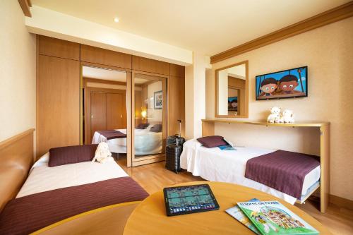 Hotel Guitart Central Park Aqua Resort في يوريت دي مار: غرفة فندقية بسريرين وطاولة