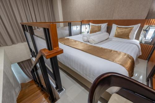 a bedroom with a large bed with white sheets at Braling Grand Hotel Purbalingga, Azana Hotels Collection in Purbolinggo