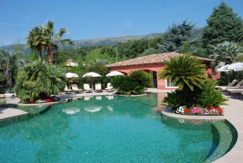a swimming pool at a resort with palm trees at Domaine De Respelido in Carros