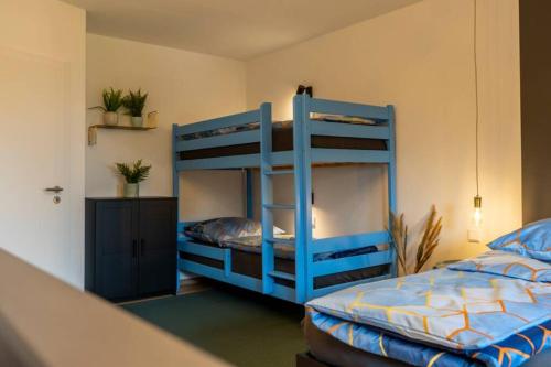 a bedroom with two bunk beds in a room at MODERN WESTERN - Apartment BLUE in Eging am See