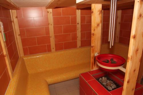 a small bathroom with a tub and a red bucket at JUFA Hotel Hochrindl in Hochrindl