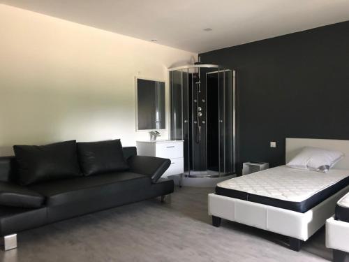 un salon avec un lit et un canapé dans l'établissement Les villas d'Hannogne, à Hannogne-Saint-Martin