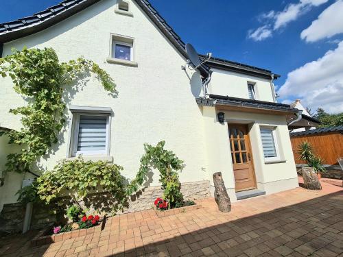 a white house with a brick driveway at Ferienwohnung zur Burg in Crölpa