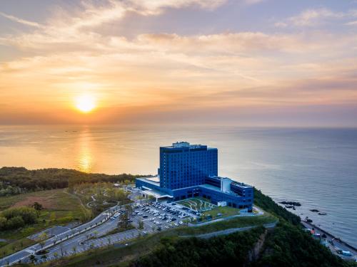 eine Luftansicht eines Gebäudes neben dem Meer in der Unterkunft Hotel Tops 10 in Gangneung