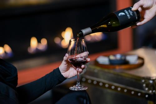 a person pouring wine into a wine glass at Rydges Armidale in Armidale