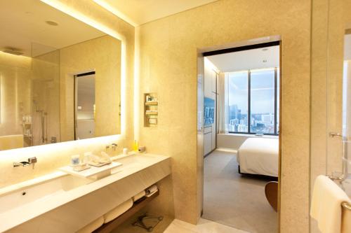 a bathroom with a sink and a large mirror at One Farrer Hotel in Singapore