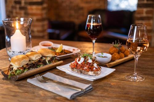 a table with two plates of food and two glasses of wine at Rydges Armidale in Armidale