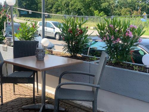 a table and chairs on a patio with plants at Swiss Hotel Krummen Eich Pratteln Free Parking in Pratteln