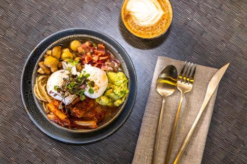 a bowl of food with eggs and vegetables on a table at Rydges Armidale in Armidale