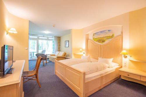 a bedroom with a bed and a living room at Emsland Hotel Saller See in Freren