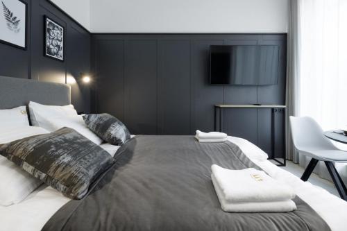 a bedroom with a large bed with a tv on the wall at Apartamenty L11, Limanowskiego in Poznań