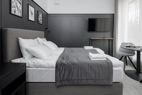 a black and white bedroom with a bed and a table at Apartamenty L11, Limanowskiego in Poznań