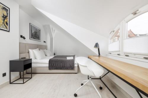 a bedroom with a bed and a desk and a chair at Apartamenty L11, Limanowskiego in Poznań