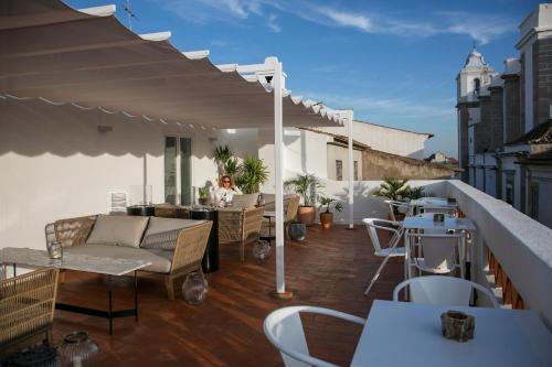 a patio with a couch and tables on a balcony at Valeriana Exclusive GuestHouse in Évora