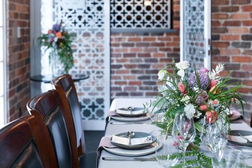 a table with plates and a vase of flowers on it at Rydges Armidale in Armidale