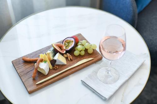 a plate of food and a glass of wine on a table at Powerhouse Hotel Tamworth by Rydges in Tamworth