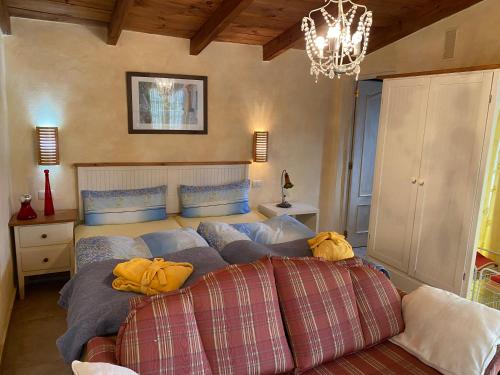 - une chambre avec un lit, un canapé et un lustre dans l'établissement La Casita, à El Jaral