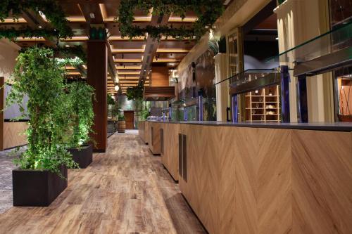 a corridor of a restaurant with potted plants at Park, Hotel & Entertainment in Nova Gorica