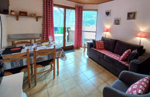 een woonkamer met een bank en een tafel bij Hameau des chaumes vue panoramique in La Bresse