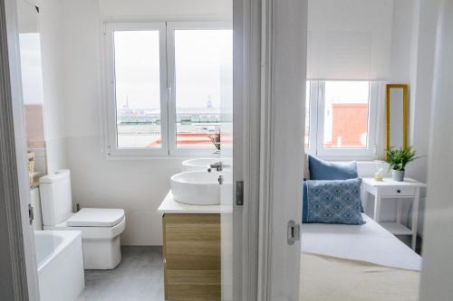 Baño blanco con 2 lavabos y aseo en Stylish City Vacation Gran Canaria, en Las Palmas de Gran Canaria