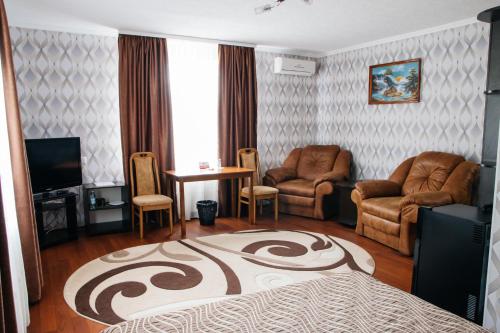 a living room with a bed and chairs and a television at Гостинний двір "Марія" in Kropyvnytskyi