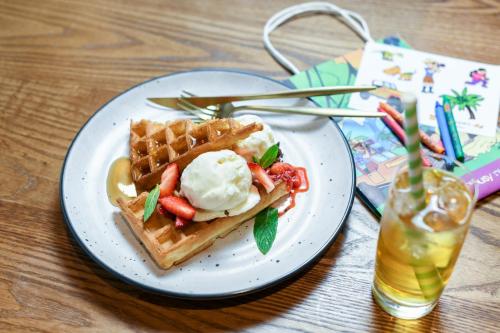 a plate of waffles and ice cream on a table at Powerhouse Hotel Tamworth by Rydges in Tamworth