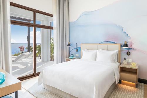 a bedroom with a bed and a large window at Vida Beach Resort Umm Al Quwain in Umm Al Quwain