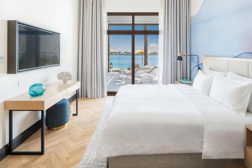 a bedroom with a large bed and a view of the ocean at Vida Beach Resort Umm Al Quwain in Umm Al Quwain