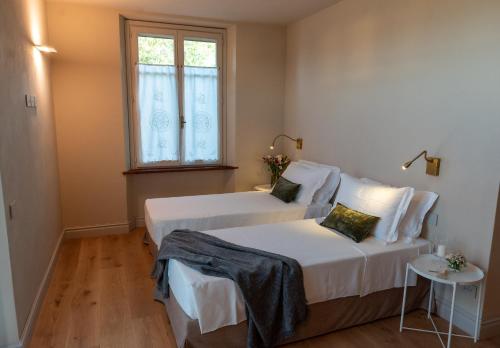 a bedroom with two beds and a window at Tenuta Pizzone Wine Resort in Rivanazzano