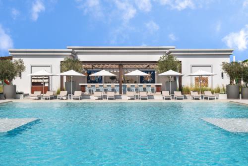 a rendering of a swimming pool with chairs and umbrellas at Vida Beach Resort Umm Al Quwain in Umm Al Quwain