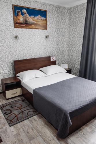 a bedroom with a bed and a painting on the wall at Гостинний двір "Марія" in Kropyvnytskyi