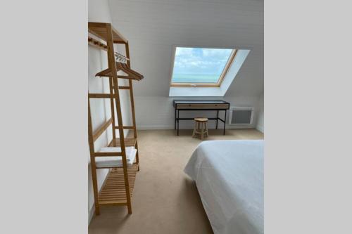 ein Schlafzimmer mit einer Leiter, einem Schreibtisch und einem Bett in der Unterkunft Agon-Coutainville, villa bord de mer in Agon Coutainville