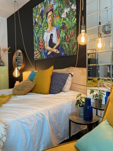 a bedroom with a bed with a painting on the wall at Uroczy apartament Art Marina z widokiem na rzekę i bezpłatnym parkingiem in Wrocław