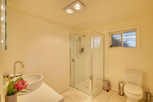 e bagno con doccia, servizi igienici e lavandino. di Quarterdeck Apartment a Binalong Bay