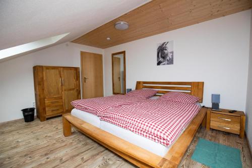 um quarto com uma cama com um edredão vermelho e branco em Ferienwohnungen Schmitt in Ehrenberg em Ehrenberg