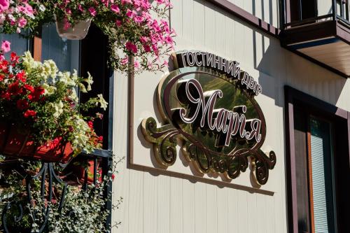 a sign on the side of a building with flowers at Гостинний двір "Марія" in Kropyvnytskyi