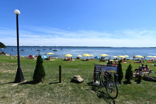 a bike parked in the grass near a beach with umbrellas at chata Modrá in Vinné