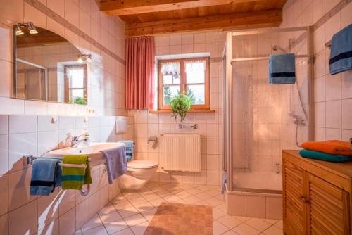 a bathroom with a sink and a toilet and a shower at Großhuberhof in Kiefersfelden