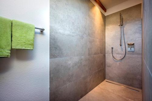 a bathroom with a shower with a green towel at Großhuberhof in Kiefersfelden