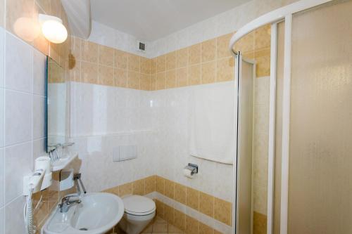 a bathroom with a toilet and a sink and a shower at Hotel pod Zámkom in Bojnice