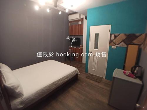 a bedroom with a white bed and a blue wall at 玖拾捌民宿-98bnb in Hualien City