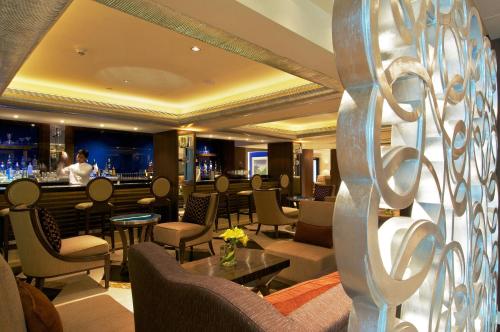 a restaurant with a bar with tables and chairs at Blue Diamond Pune IHCL SeleQtions in Pune