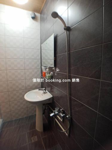 a bathroom with a sink and a shower with a mirror at 玖拾捌民宿-98bnb in Hualien City