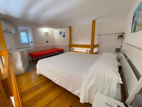a bedroom with a white bed and a red bench at Magi - Zeus in Ponza